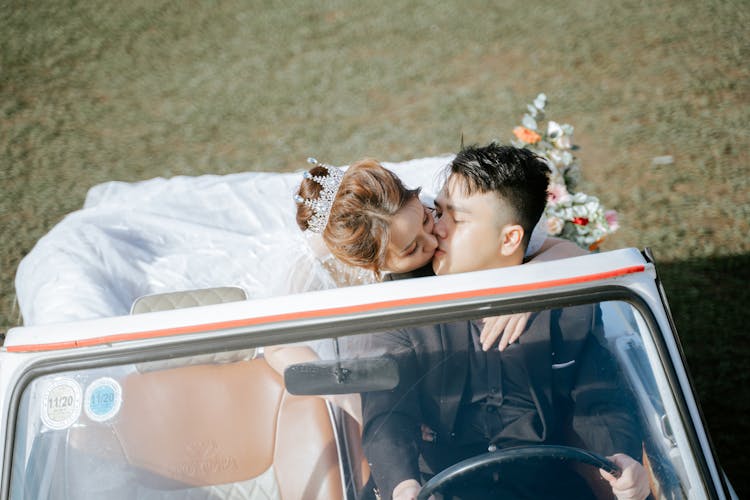 Happy Asian Newlyweds Kissing In Retro Car