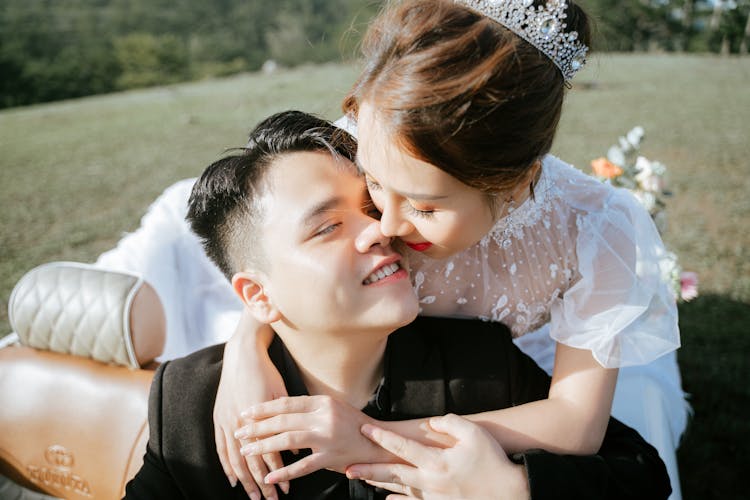 Happy Newlywed Asian Couple Embracing In Vintage Car