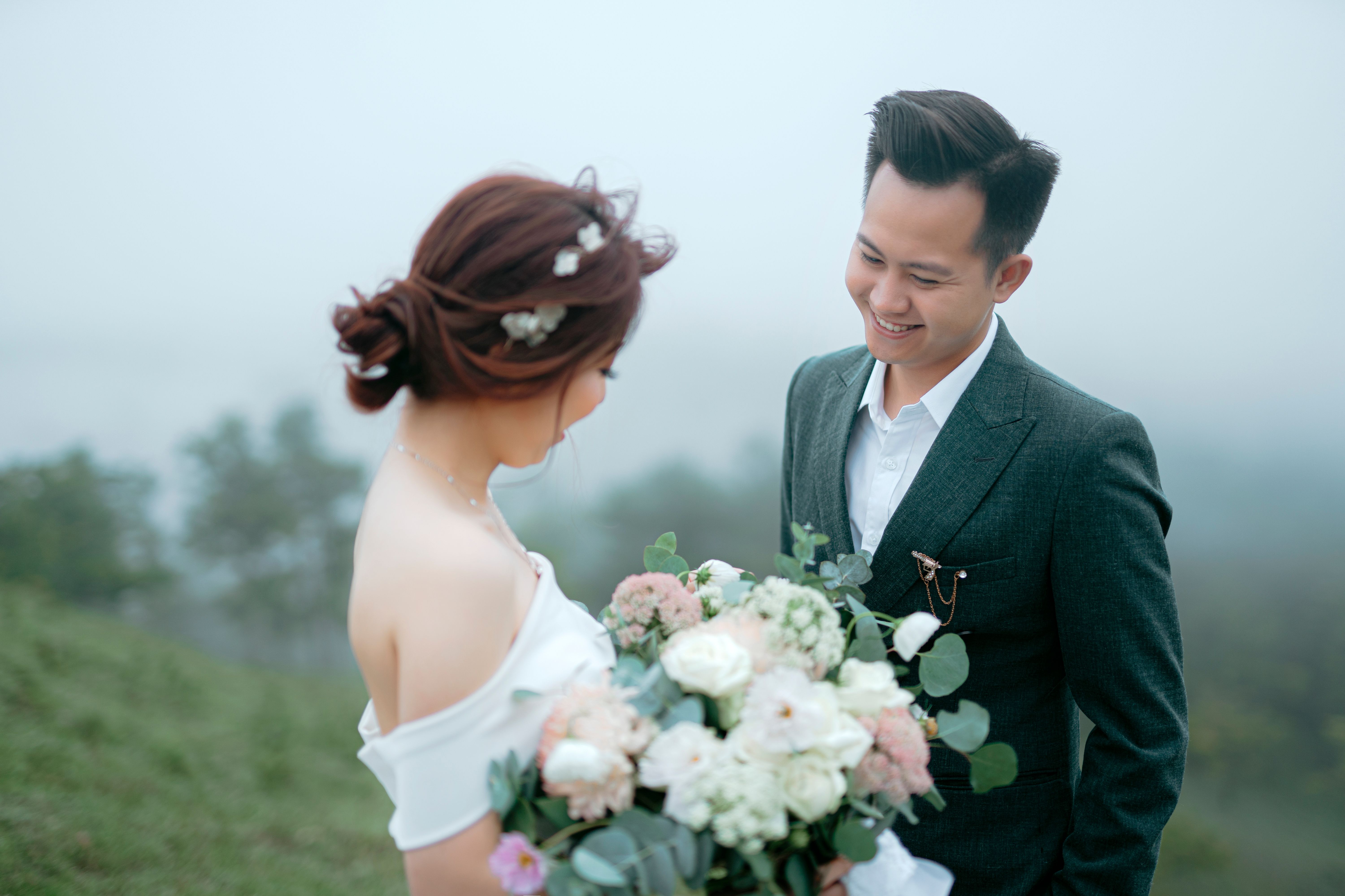 一对亚洲夫妇迷人的户外婚礼照片，拥抱爱与自然