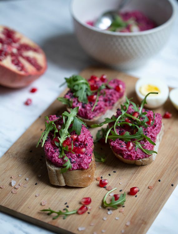pieces of bread with beetroot dressing on a wooden board