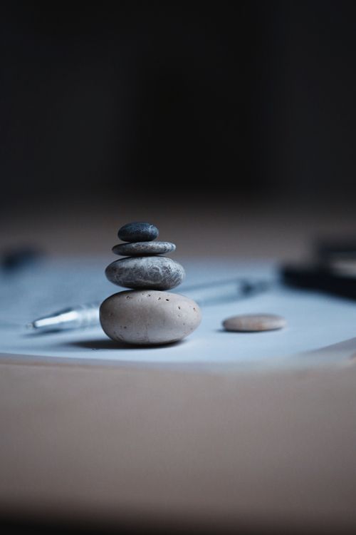 Free Close-up of balanced stones on paper with pen, showcasing harmony and focus. Stock Photo