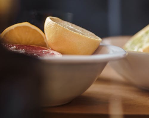 Free Delicious cut grapefruits in bowl on table Stock Photo