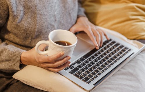 Cortar Freelancer Com Uma Caneca De Café Digitando No Laptop