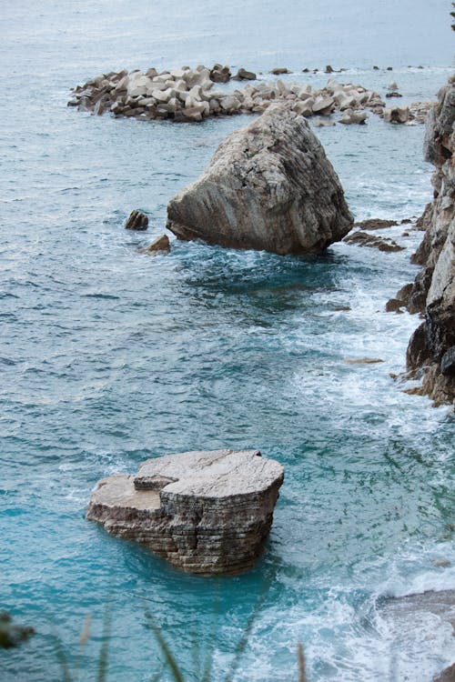 Rocky formations on shallow blue seawater