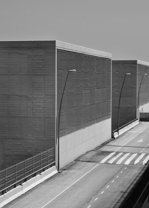 Free Black and white of concrete constructions with metal grid with fence located near asphalt road with marking lines on street in city Stock Photo