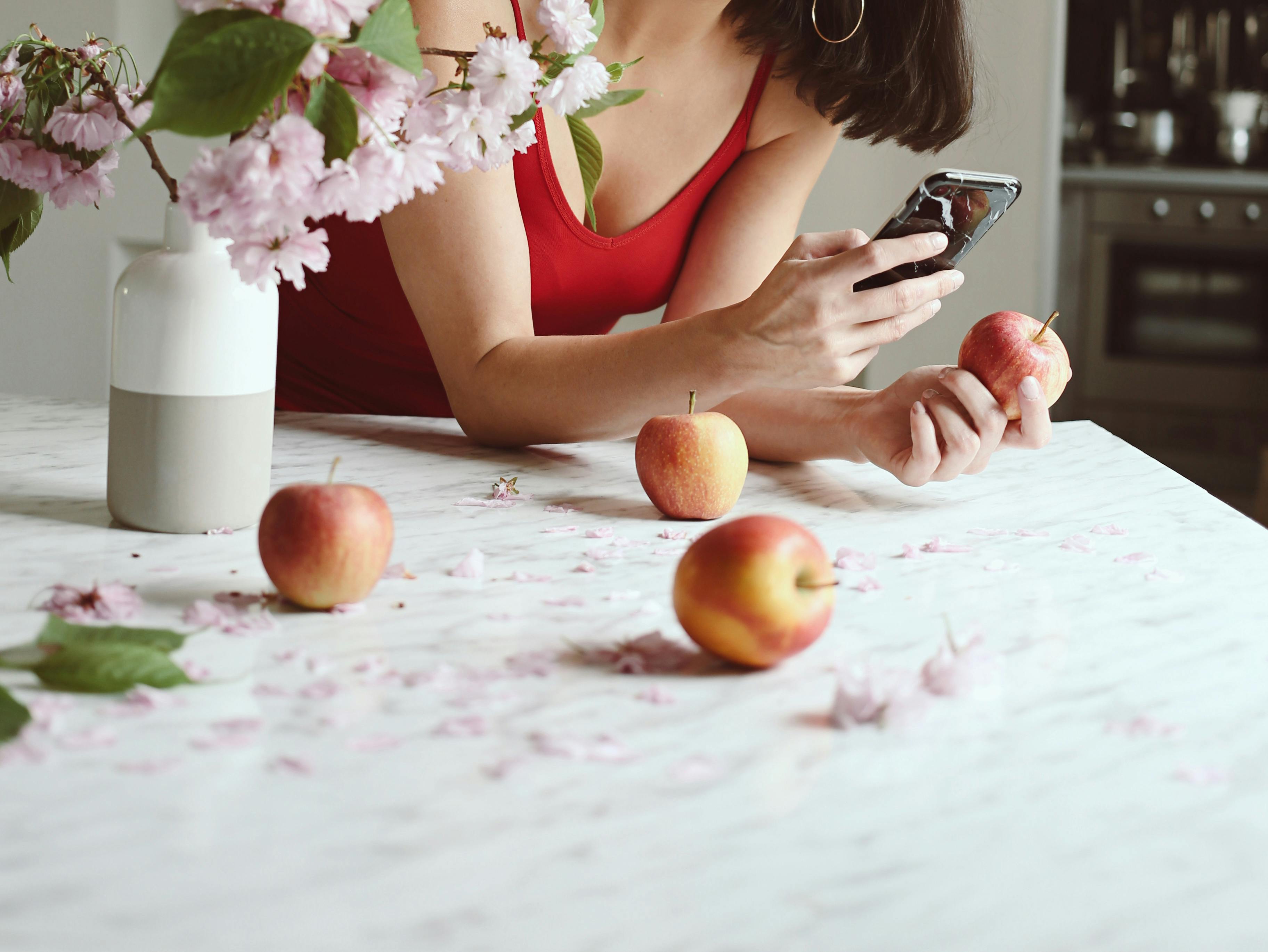 crop woman with smartphone at table