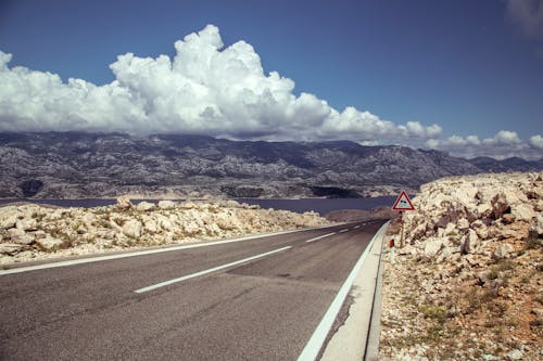 Empty asphalt roadway among rocky hills