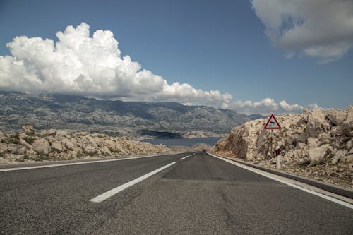 Wide asphalt road through mountainous terrain