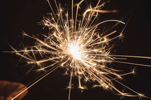 Free Crop person with sparkler in darkness Stock Photo