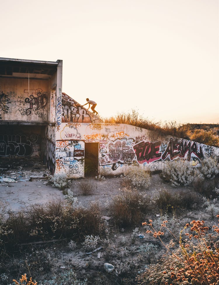 A Person Climbing On An Abandoned Building