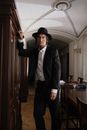 Man in Black Suit Standing Near Brown Wooden Door