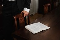 Person in Black Suit Jacket Holding White Printer Paper
