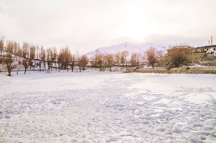 A Field Covered In Snow And Mountains In The Horizon 