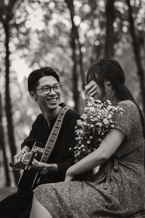 Free Asian couple with guitar in park Stock Photo