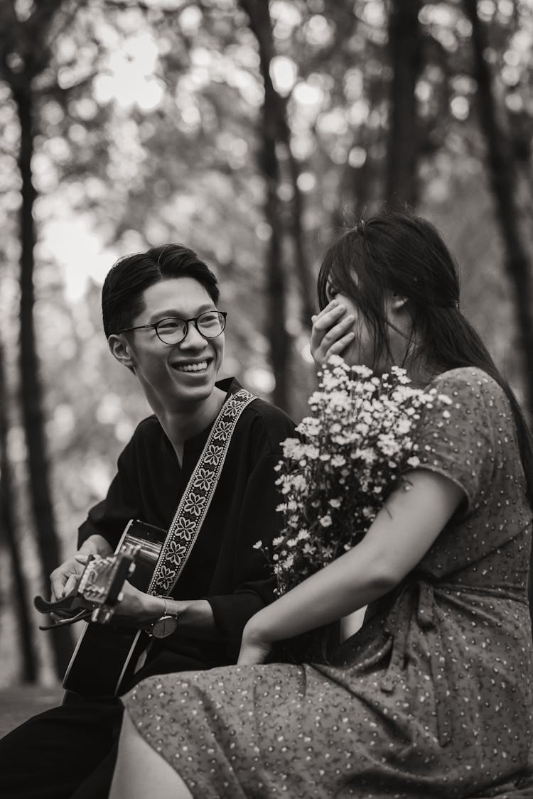 Asian Couple With Guitar In Park