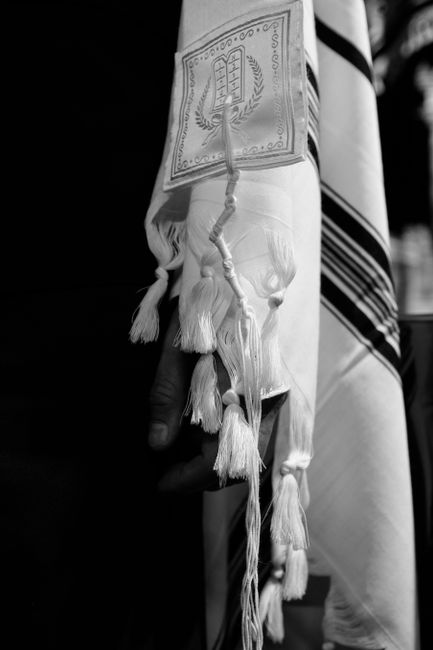 Detailed black and white image of a tallit with fringes symbolizing Jewish tradition and religion.