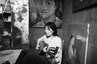 Woman Singing While Playing a Guitar