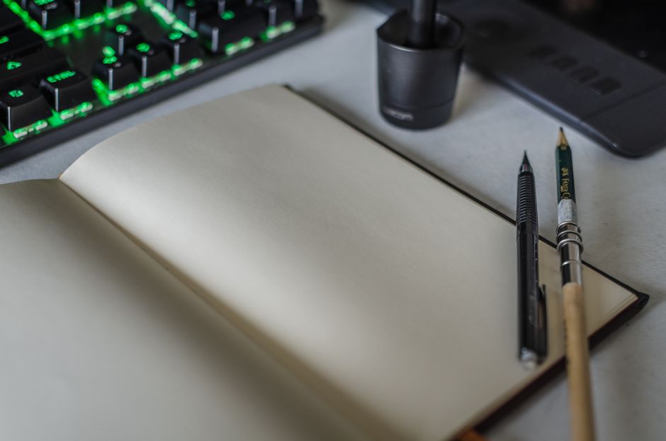 home desk with simple creative materials already visible notebook pen sketchbook lifestyle photo 1