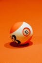 Billiard ball with number on bright orange surface for complex intellectual board game