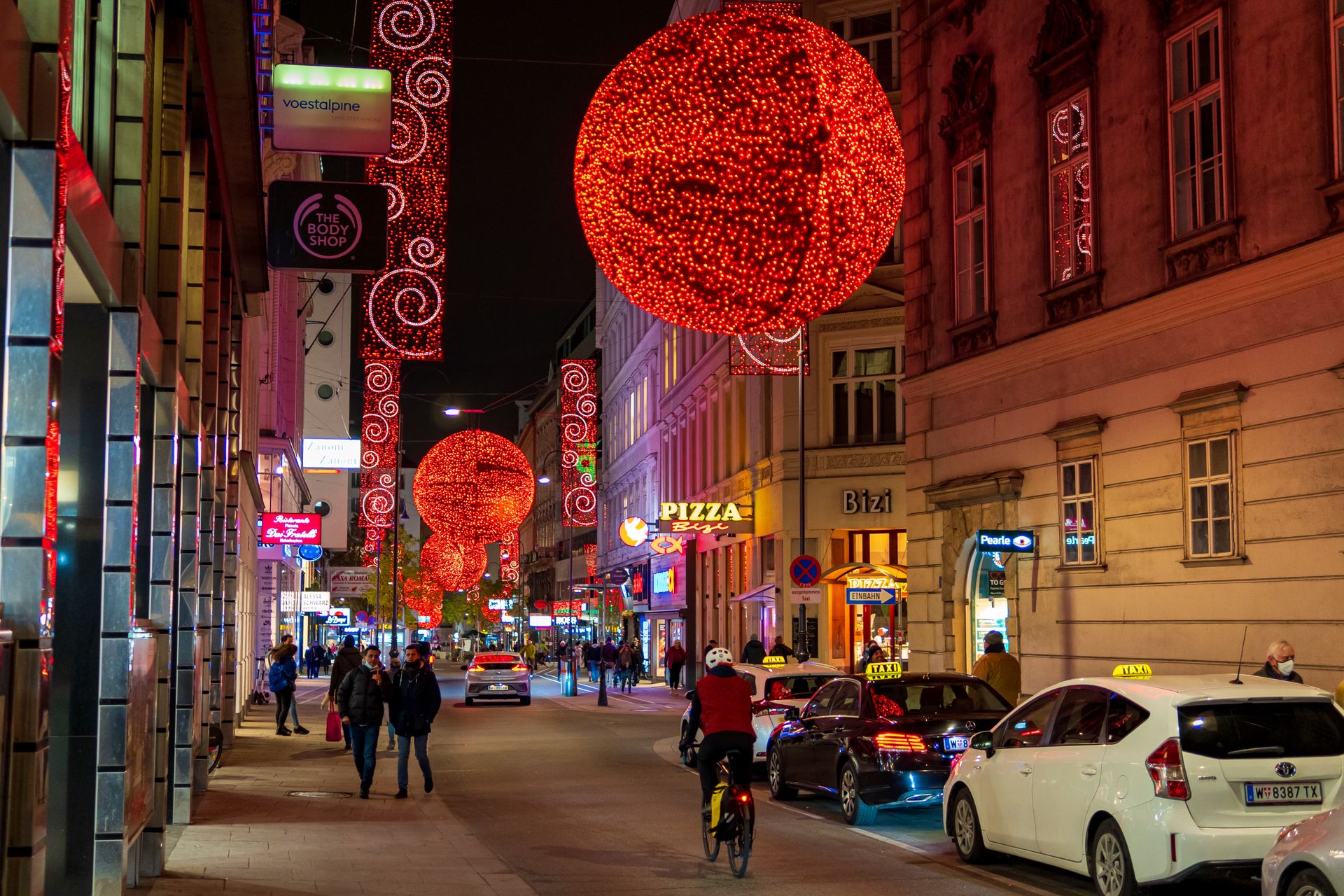 Vibrant Christmas street scene in Vienna with dazzling lights and lively activity.