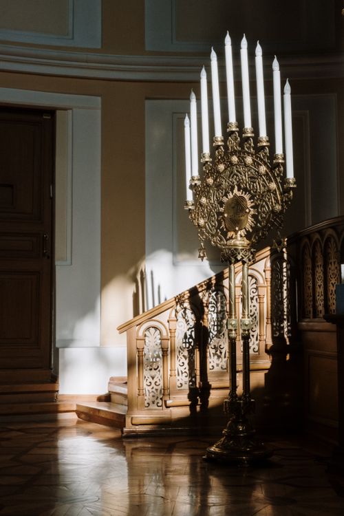 Free A vintage candelabrum casting shadows in a beautifully designed interior setting with wooden stairs. Stock Photo