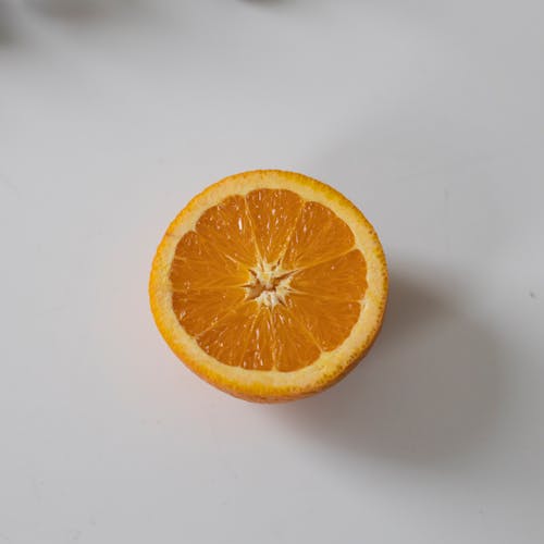 Free From above of sliced half juicy fresh ripe orange placed on white table Stock Photo