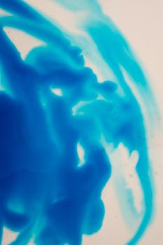 Abstract background of bright blue color ink diffusing slowly in clear water on white background