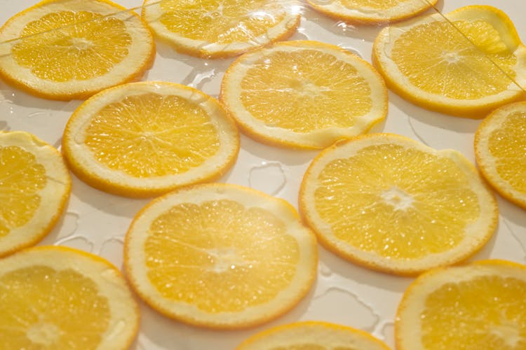 Slices Of Orange With Juice On White Table