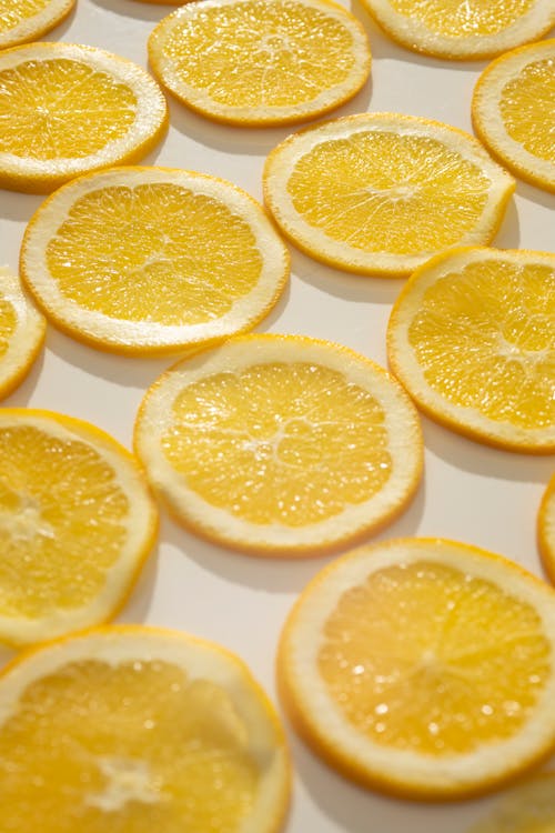 Background set of delicious fresh juicy orange slices placed on white surface in sunlgiht