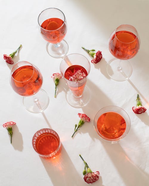 Glasses and flowers on white surface