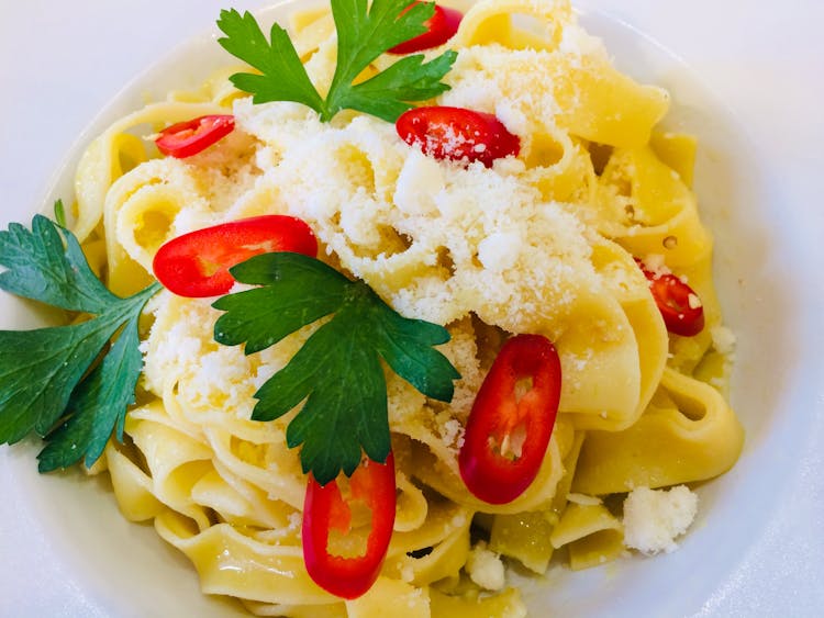 Pasta With Sliced Tomatoes On White Ceramic Plate