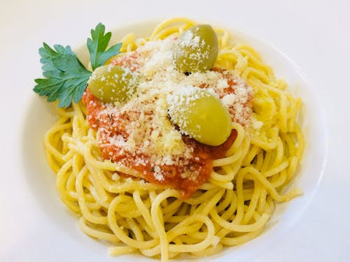 Pasta With Green Leaves on White Ceramic Plate