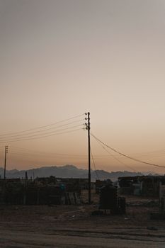 在宁静的日落天空映衬下，远处的山脉和电线轮廓分明