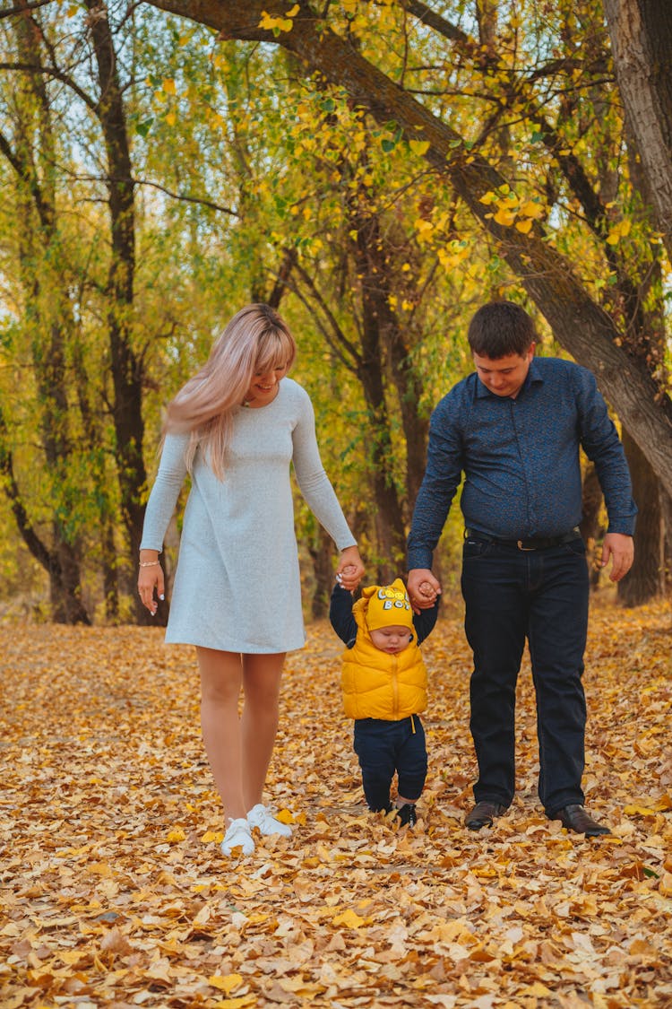 Happy Family Walking In Fall Park