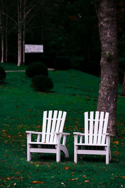 White Wooden Chairs on Green Grass Field