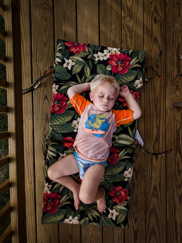 Cute Little Boy Sleeping On Mattress