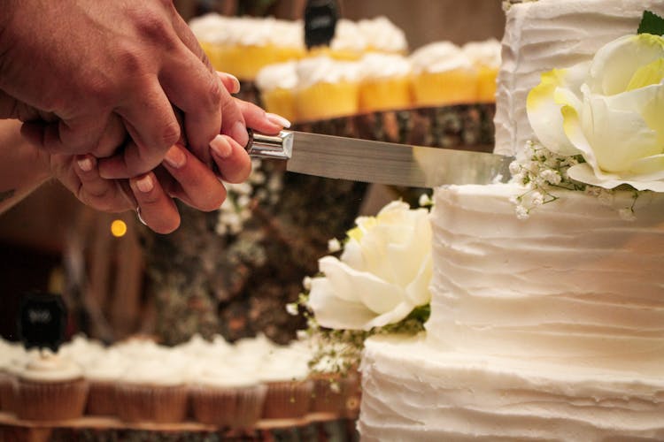 Crop Newlyweds Cutting Wedding Cake Together