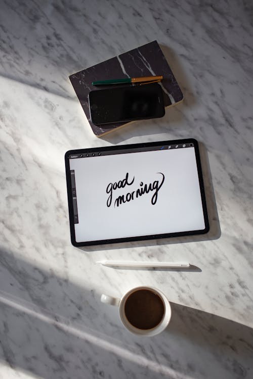 A Tablet Near the Coffee on a Marble Table Top