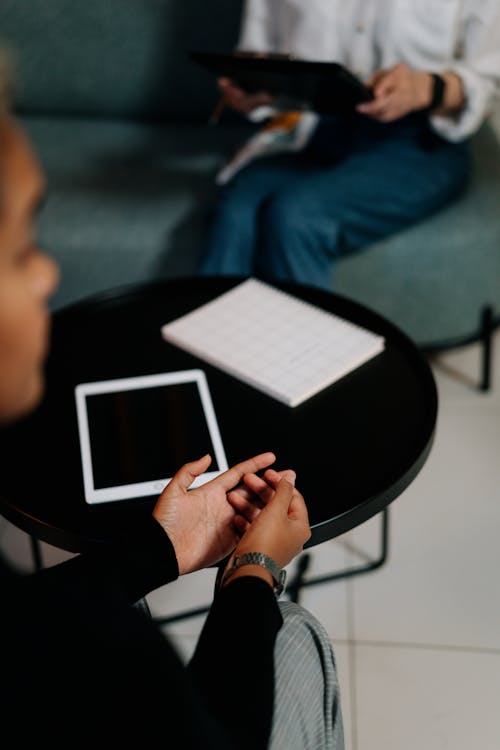 Woman in Blue Denim Jacket Holding White Tablet Computer