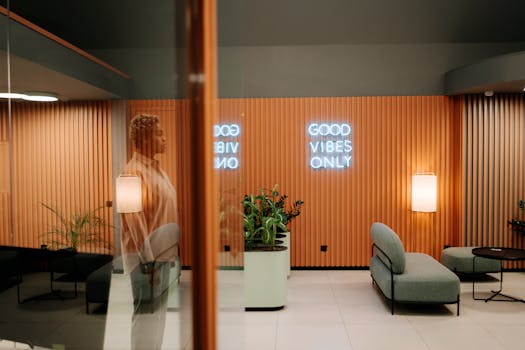 A stylish lobby with a 'Good Vibes Only' neon sign, reflecting contemporary interior design.