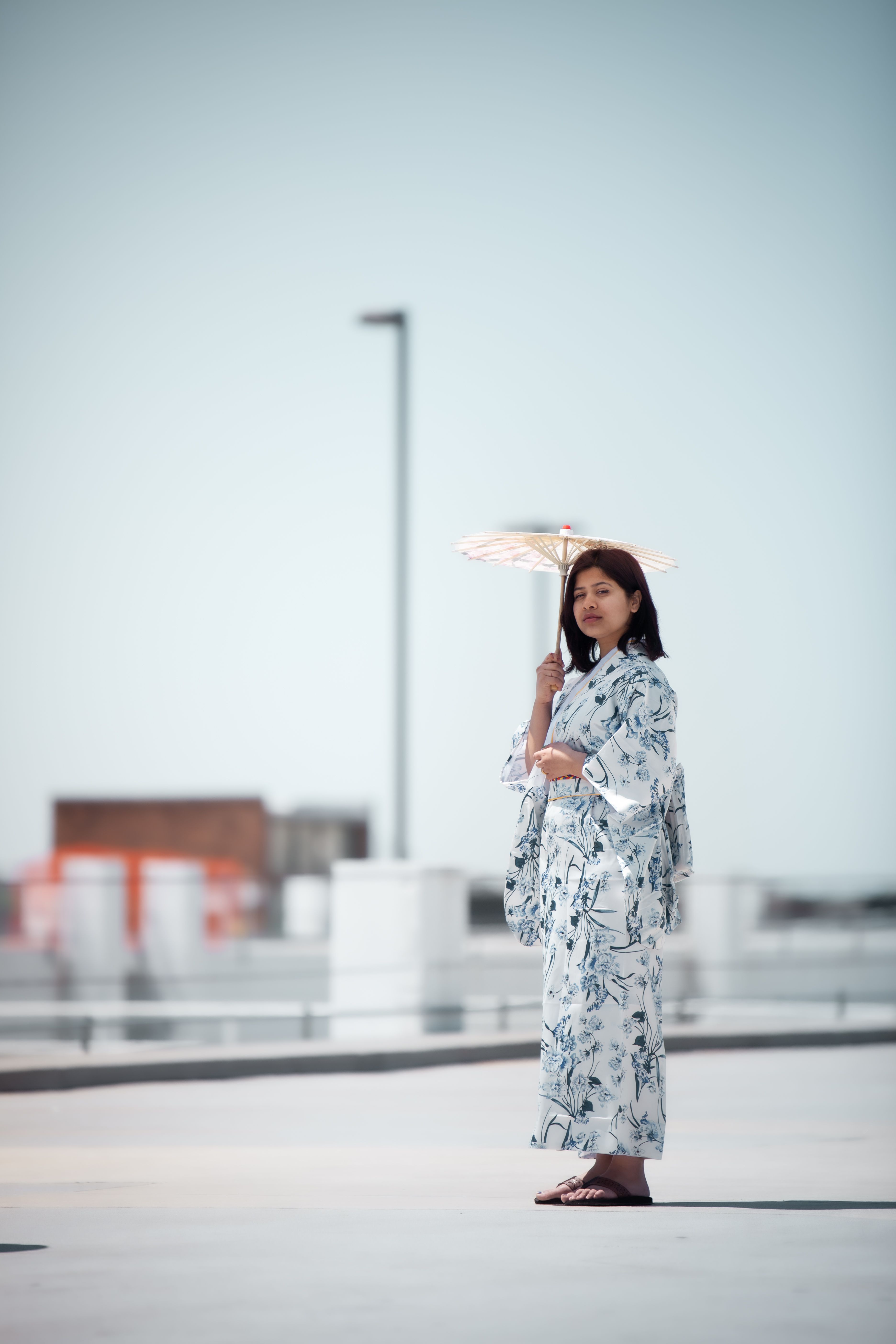 一位穿着和服的优雅日本妇女撑着和笠伞，站在户外