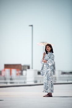 一位穿着和服的优雅日本妇女撑着和笠伞，站在户外