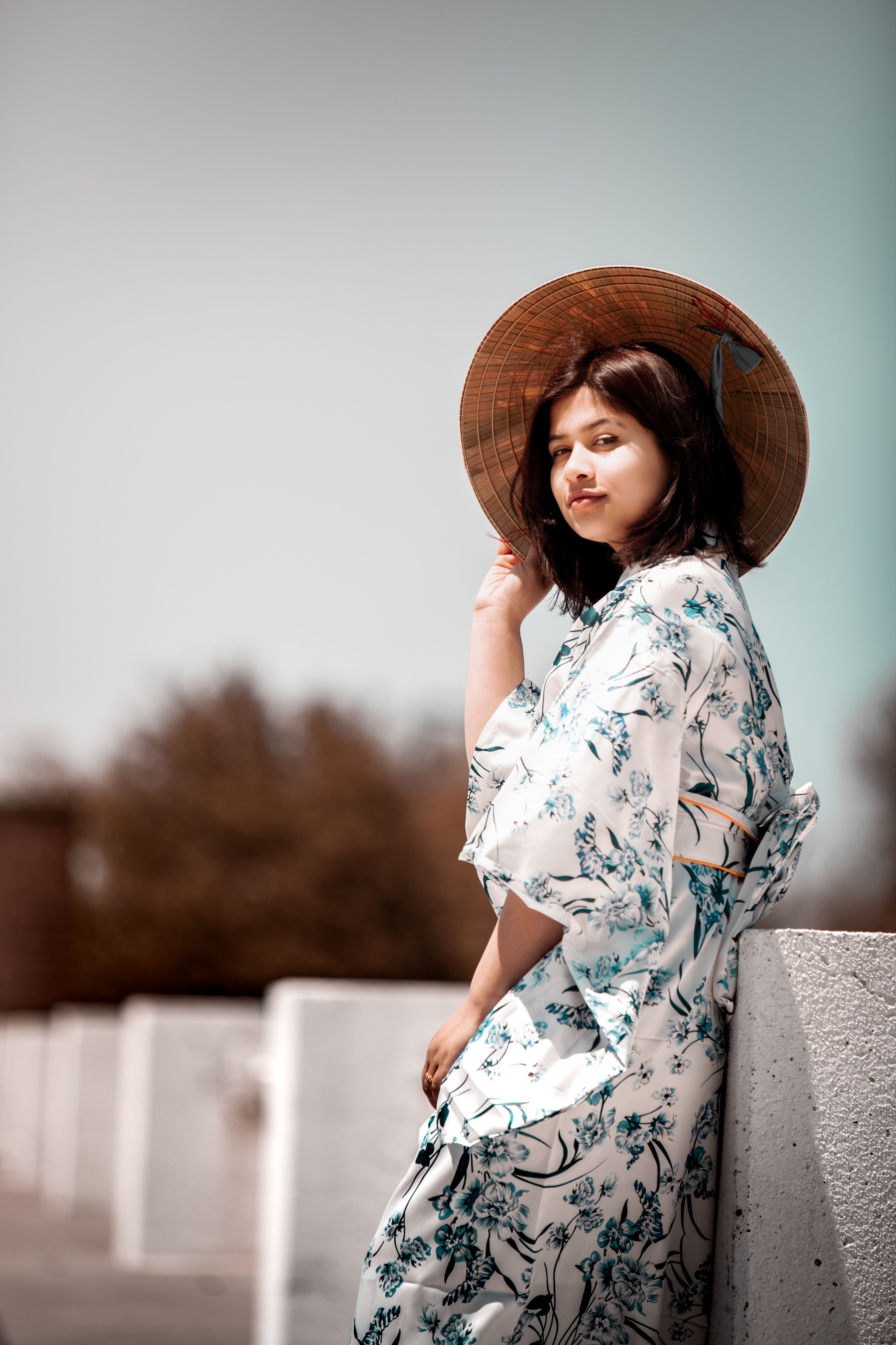 身着花卉和服、头戴圆锥帽的女性，其优雅的户外肖像体现了文化之美