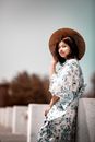 身着花卉和服、头戴圆锥帽的女性，其优雅的户外肖像体现了文化之美