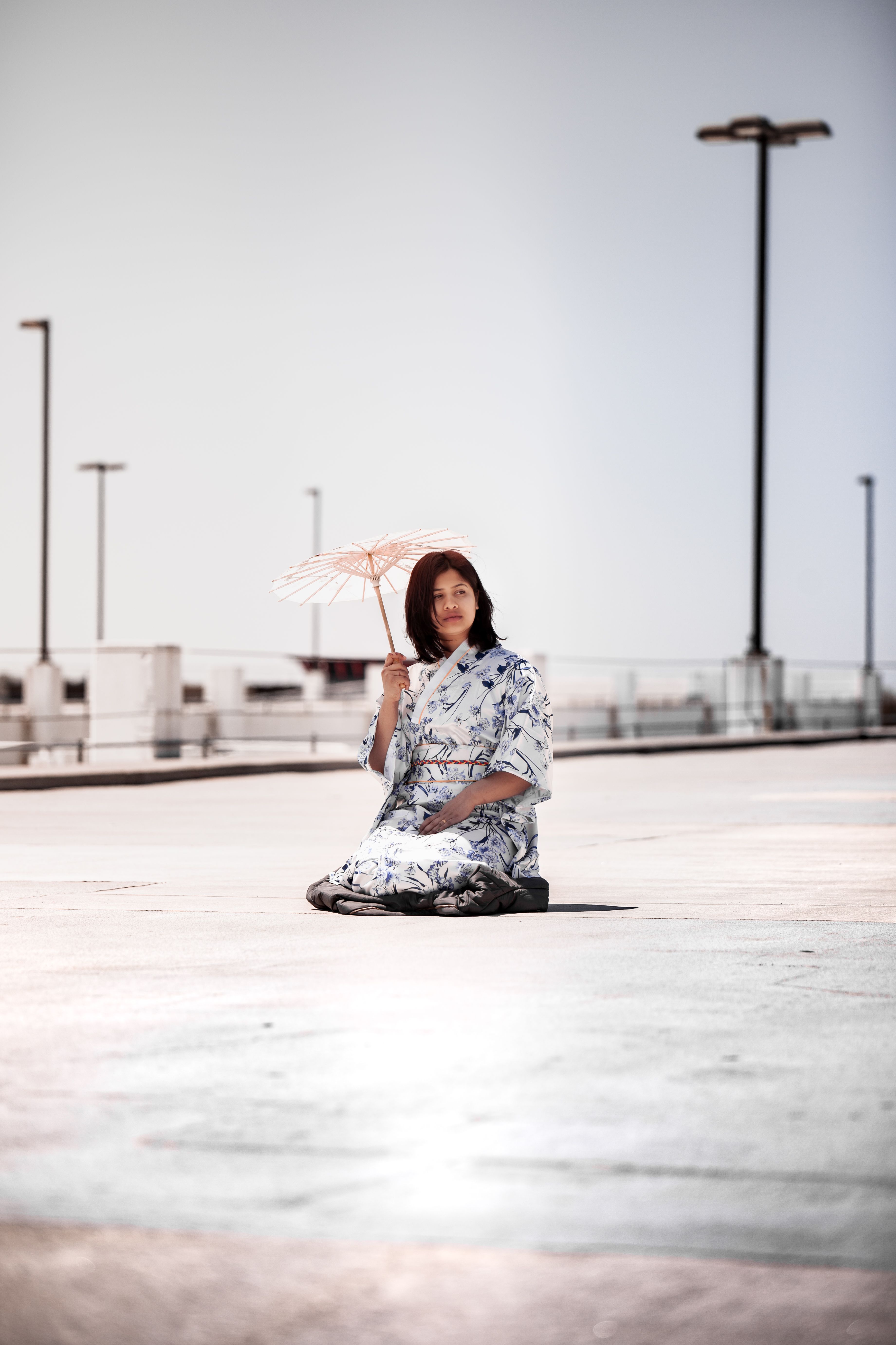 一位穿着和服的女子撑着伞坐在户外，展现了日本文化