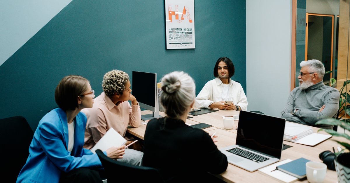 Teambesprechung im Büro – Führungsebenen stimmen sich über Zuständigkeiten und Objektverteilung ab