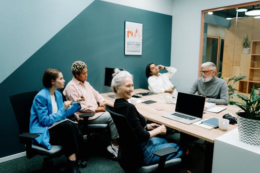 A diverse group of colleagues engaged in a meeting at a modern office, fostering teamwork and communication.