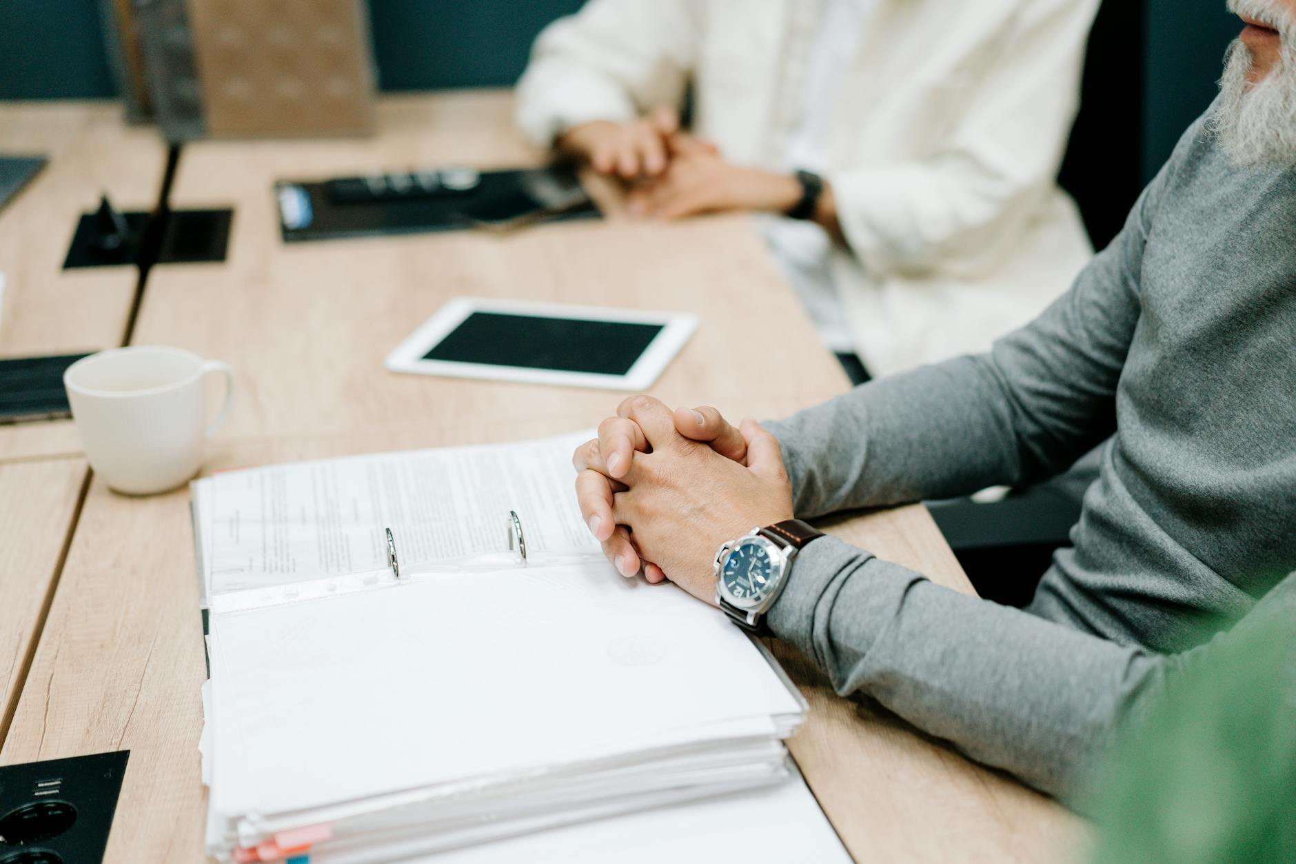 Close-up of a business meeting with documents and digital tablet on a wooden desk. entry level project manager jobs.