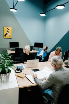 Diverse team discussing business strategy in modern office setting.