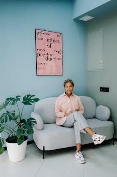 A professional sits on a stylish sofa in a contemporary office, showcasing a blend of comfort and modern design.